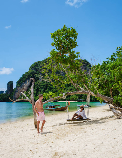Ostrov Koh Phakbia se nachází v blízkosti Ko Hong Krabi, krásné bílé písečné pláže v Krabi Thajsku. Mladé asijské ženy a evropští muži na pláži během dovolené v Thajsku. - Fotografie, Obrázek