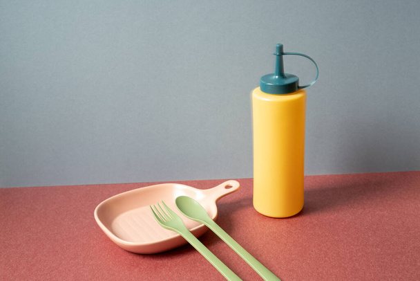 Vajilla de cocina colorida sobre mesa roja. fondo de pared gris - Foto, Imagen