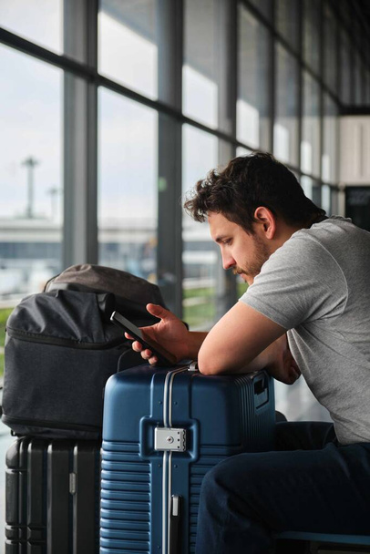 Чоловік робить реєстрацію на своєму смартфоні в аеропорту Наріта. - Фото, зображення