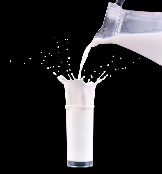 Mléko je lití ze džbánu láhve do sklenice s logem na černém pozadí. - Fotografie, Obrázek