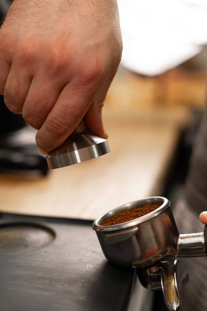 Barista tenant portafilter et falsificateur de café faire un expresso dans le café, gros plan. Espace de copie - Photo, image