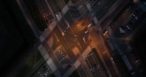 Een luchtfoto van een verkeersknooppunt in Amsterdam met voetgangers, fietsers, auto 's en tramrails - Video