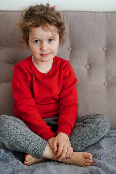 niña sentada en casa en el sofá, feliz infancia - Foto, Imagen