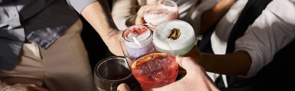 vue recadrée de collègues multiethniques qui claquent des verres avec des boissons alcoolisées dans un bar à cocktails, bannière - Photo, image