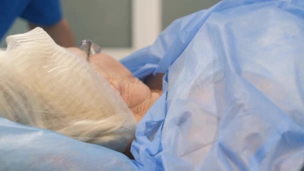Zur Vorbereitung der älteren Frau auf die Operation gehört es, sie sorgfältig auf den Eingriff vorzubereiten und Narkose zu verabreichen, um ihren Komfort und ihre Sicherheit während der Operation zu gewährleisten.. - Filmmaterial, Video