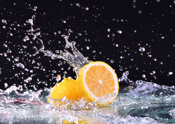 Макро-водяной брызг на лимон. Капли воды с сочным лимоном
 - Фото, изображение