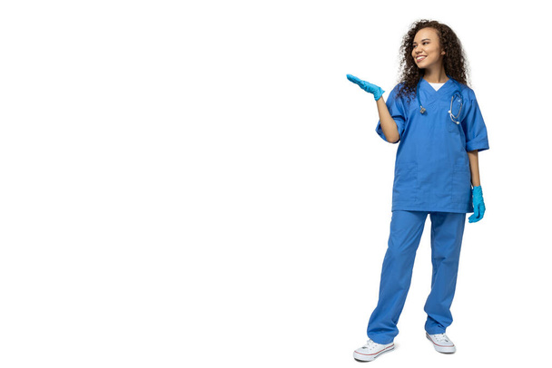 白い背景に隔離された青い看護婦の制服の少女 - 写真・画像