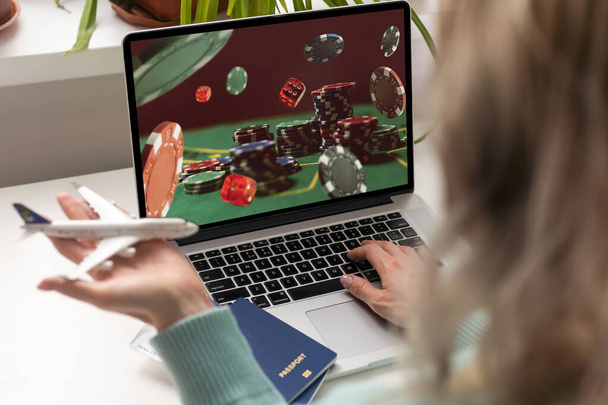 Online gokken, weddenschappen concept. Poker chips, casino roulette op laptop en telefoon schermen. Man die met een computer werkt en een smartphone vasthoudt, kantoorachtergrond. Hoge kwaliteit foto - Foto, afbeelding