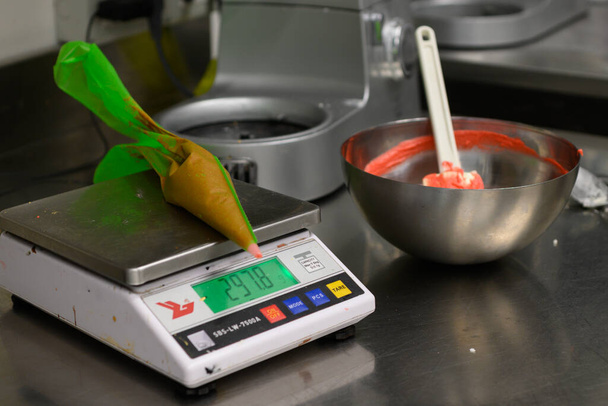 кондитер стир красный сливочный крем для украшения торта на профессиональной кухне - Фото, изображение
