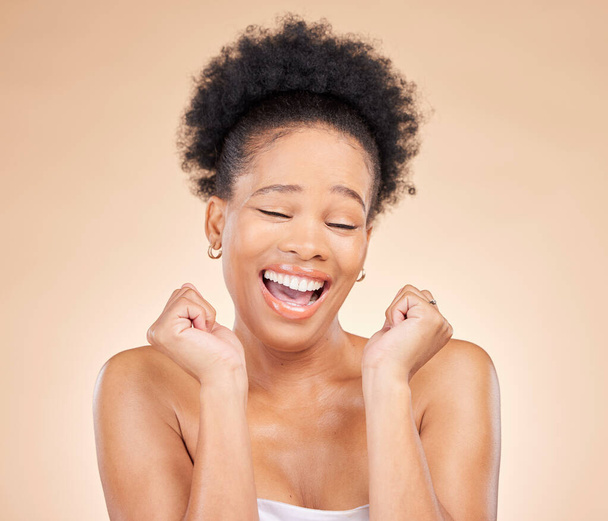 Soin de la peau, excité et jeune femme noire dans un studio avec routine cosmétique, lumineux et naturel visage. Happy, sourire et modèle féminin africain avec traitement dermatologique facial isolé par fond brun - Photo, image
