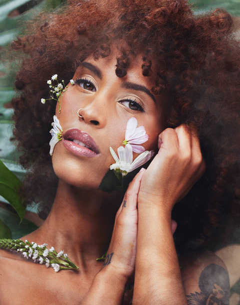 Black woman, art and portrait for skincare with flowers in beauty, creative or eco friendly cosmetics from nature or forest. Natural, face and model with flower makeup or healthy organic skin care. - Foto, Imagem