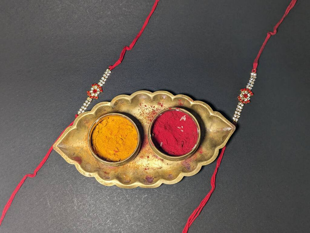 Raksha Bandhan, indisches Festival mit wunderschönem Rakhi im schwarzen Hintergrund. Ein traditionelles indisches Armband, das ein Symbol der Liebe zwischen Schwestern und Brüdern ist. - Foto, Bild