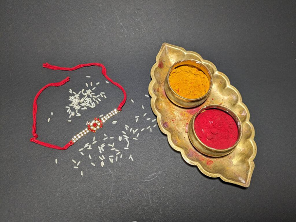 Raksha Bandhan, festival indien avec beau Rakhi en fond noir. Un bracelet traditionnel indien qui symbolise l'amour entre sœurs et frères. - Photo, image