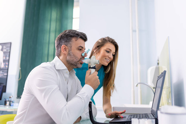 L'uomo adulto prova la funzione respiratoria mediante spirometria che ha problemi di salute. Diagnosi della funzione respiratoria nelle malattie polmonari. - Foto, immagini