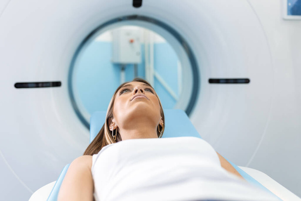Femme faisant l'objet d'une tomodensitométrie alors que le médecin utilise des ordinateurs. Patient allongé sur le lit du scanner TC attendant d'être scanné. - Photo, image