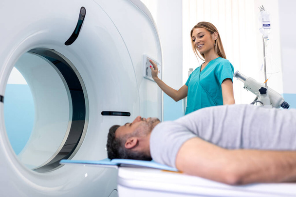 Doktorka dívá na pacientku podstupující CT sken. Lékař v uniformě pomocí tomografie stroj s ležící pacient v nemocnici - Fotografie, Obrázek