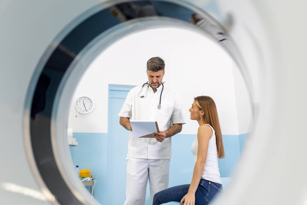 Mužský lékař poskytující informace ženě před vyšetřením MRI. Zobrazovací technologie magnetické rezonance ve specializované lékařské klinice. - Fotografie, Obrázek