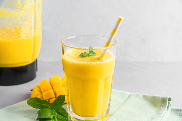 Sağlıklı yaz içeceği yapmak için taze meyve suyu ve blender ile bir bardak sarı mango smoothie. Yemek pişirme konsepti - Fotoğraf, Görsel
