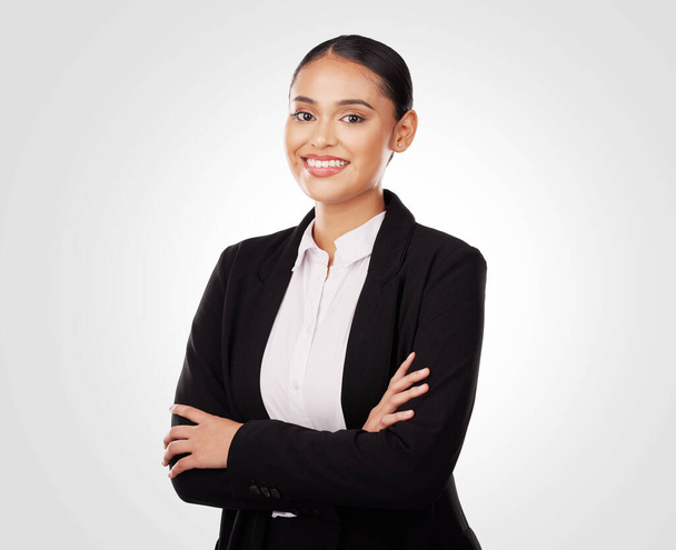 Crossed arms, smile and portrait of businesswoman in a studio with positive and confident attitude. Happy, professional and young Indian female corporate lawyer attorney isolated by white background - Photo, Image