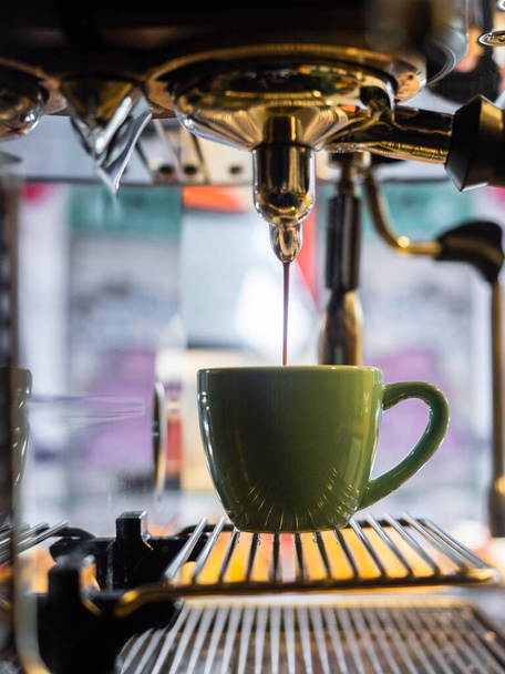 Coffee pouring from an espresso machine into a cup - Photo, Image