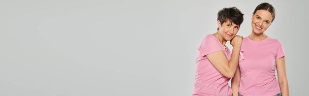 concepto de conciencia del cáncer de mama, dos mujeres con cintas de color rosa sobre fondo gris, libre de cáncer, pancarta - Foto, Imagen