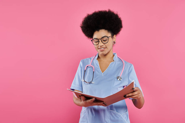 consciência do câncer de mama, médico americano africano, oncologista feliz lendo prontuário médico, pasta - Foto, Imagem