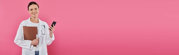 ευαισθητοποίηση του καρκίνου του μαστού, γυναίκα γιατρός, χαρούμενος ογκολόγος με φάκελο χρησιμοποιώντας smartphone, banner - Φωτογραφία, εικόνα