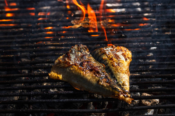 Grilled mackerel fish with smoke on a charcoal barbecue grill. - Photo, Image