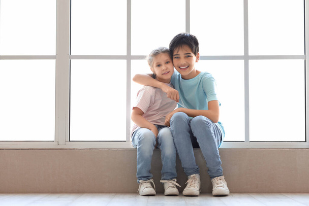 Kleiner Junge mit seiner Schwester am Fenster - Foto, Bild