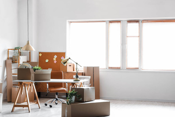 Moderne werkplek met kartonnen dozen op kantoor op verhuisdag - Foto, afbeelding