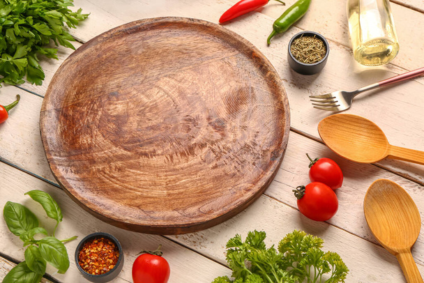Composición con tablero de cocina, especias, verduras y hierbas sobre fondo de madera clara - Foto, imagen