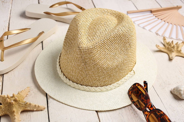 Set of beach accessories with stylish hat on light wooden background - Photo, Image