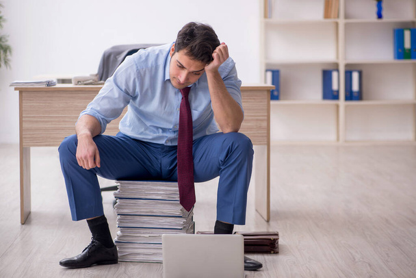Young employee unhappy with excessive work at workplace - Foto, imagen