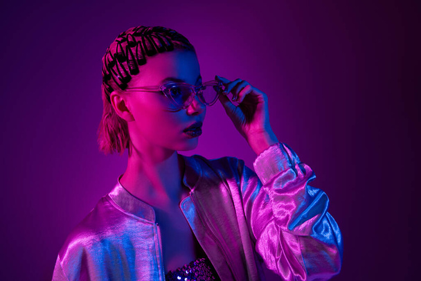 Kuva tyylikäs moderni nainen näyttää profiilin sivukosketus silmälasit elokuvallinen yö tapahtuma yli neon ultravioletti tausta. - Valokuva, kuva