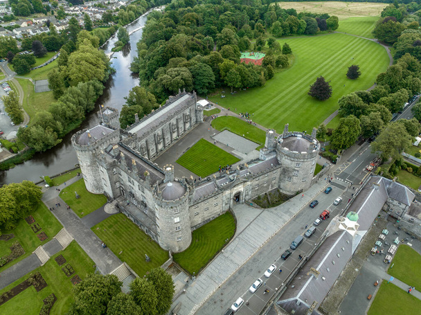 Kilkenny várának légi kilátása, középkori védőszerkezet viktoriánus átépítése, gördülő park, teraszos rózsakert, erdők, mesterséges tó a Nore folyó partján - Fotó, kép