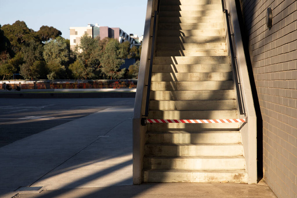 Οι εξωτερικές σκάλες είναι μπλοκαρισμένες με ταινία προειδοποίησης κινδύνου, περιορίζοντας την πρόσβαση για λόγους ασφαλείας. - Φωτογραφία, εικόνα