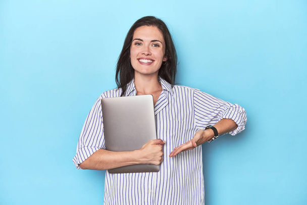 Businesswoman with laptop against blue background - Photo, Image
