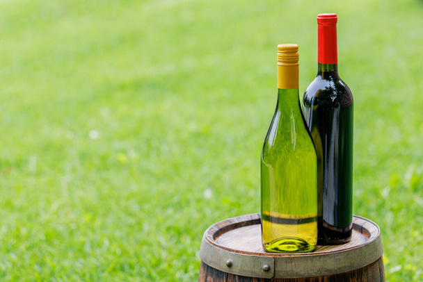 Wine bottles on wine barrel outdoors with copy space - Photo, Image