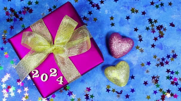щасливий новий рік 2025 фон новорічні канікули листівка з яскравими вогнями, подарункова коробка та серце блищить іграшками з зірками конфетті на синьому гранжевому фоні - Кадри, відео