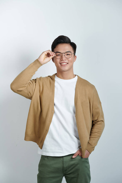 Handsome stylish young man touching eyeglasses and posing - Fotografie, Obrázek