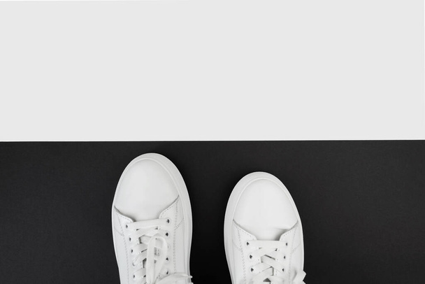 верхний вид белых кроссовок на черно-белом фоне с копировальным пространством. - Фото, изображение