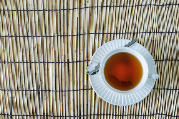 Το φλιτζάνι λευκό τσάι στο ξύλινο χαλί - Φωτογραφία, εικόνα