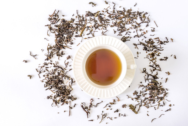 weiße Teetasse mit Tee und Teeblatt - Foto, Bild