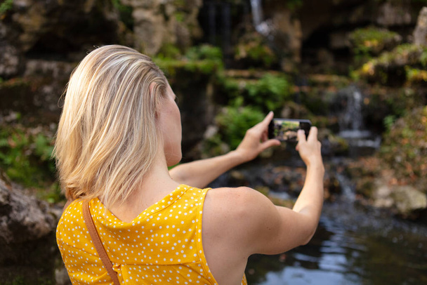 woman using a camera to take photo at the park - Φωτογραφία, εικόνα
