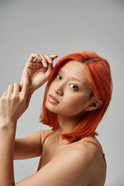 portrait of pretty asian woman with dyed hair looking at camera on grey background, natural beauty - Φωτογραφία, εικόνα
