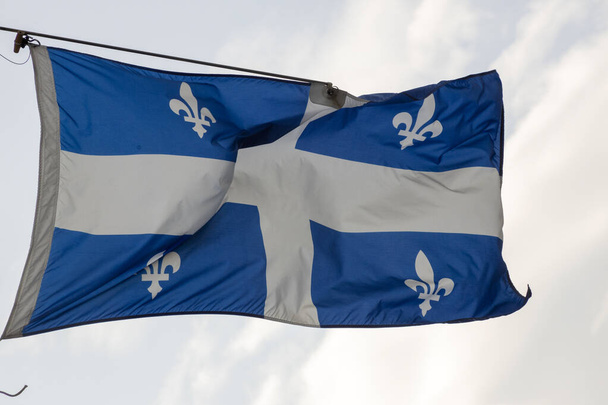 Nationale vlag van Quebec op een vlaggenmast wapperend op een wind - Foto, afbeelding