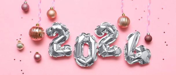 Figure 2024 faite de ballons et de boules de Noël sur fond rose - Photo, image