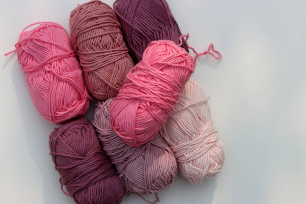 Pink and purple clews of yarn close up photo. Beautiful soft organic cotton on a table.  - Photo, Image