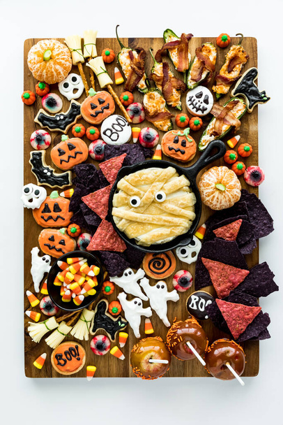 Vue du haut vers le bas d'une planche de charcuterie d'Halloween remplie de créatures comestibles effrayantes - Photo, image