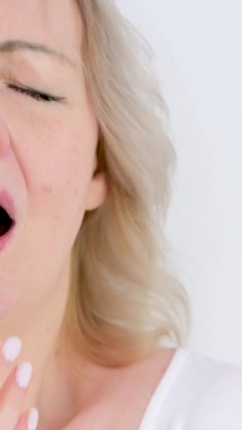 hidasliikkeinen kausiluonteinen allergia kylmä kuiva ilma lähikuva nainen aivastaa peittää kätensä valkoisella taustalla vetiset silmät nuolee huulet epämiellyttävä tunne - Materiaali, video